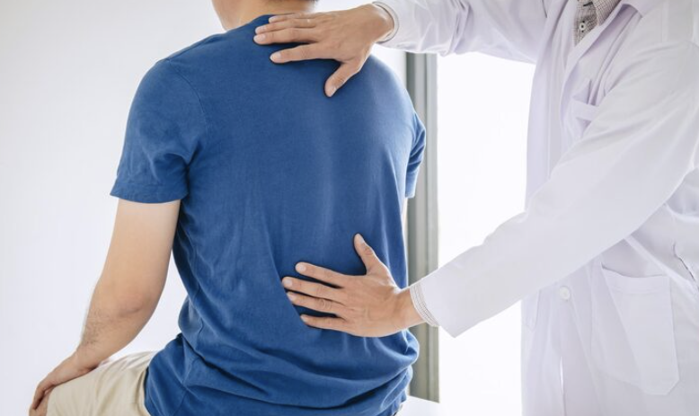 physiotherapist examining a patients spine