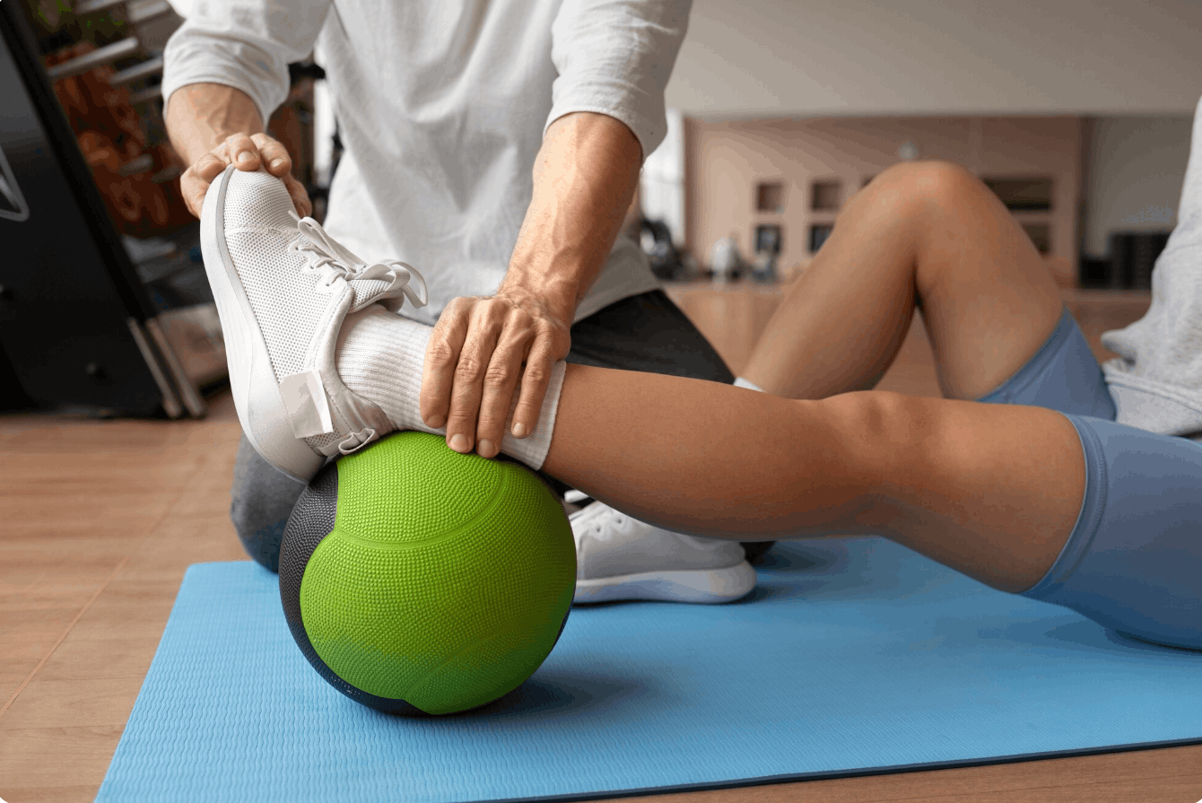 physiotherapist rolling a patients ankle on a ball