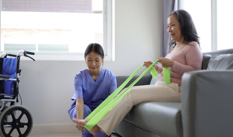 physiotherapist guiding a patient how to use a stretching band